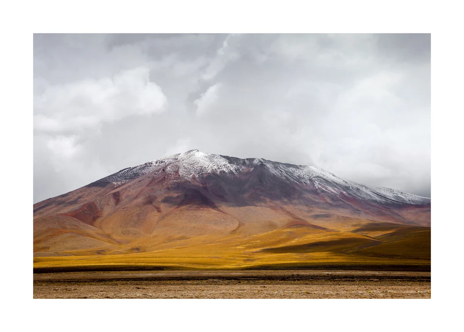 Colorful mountain with a snowcapped peak touching the sky up the sky.