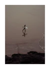 Surfer in a black wetsuit carrying a small board heading out to sea.