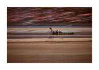 Blurry image of a cast going fast on a race car track.