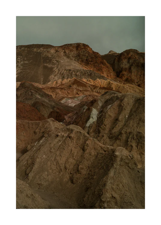 Rough mountain scenery with brown and orange cliffs captured from above.