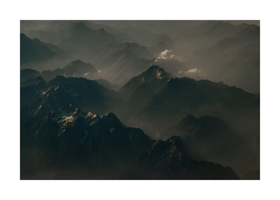 Birds view of a dark mountain scenery obscured by white mist.