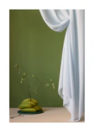 Still life image of bananas, grass growing out of them next to a white curtain.