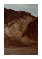 Tiny man walking along the bottom of a massive brown and beige mountain.