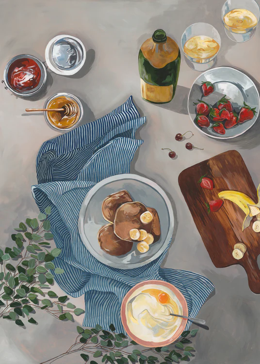 The Breakfast of Champions Poster displays fluffy pancakes topped with bananas, a bowl of yogurt with honey, strawberries and cherries on a cutting board, and a striped cloth adorning the table. Drinks and sauce bowls are nearby alongside a vibrant green plant.