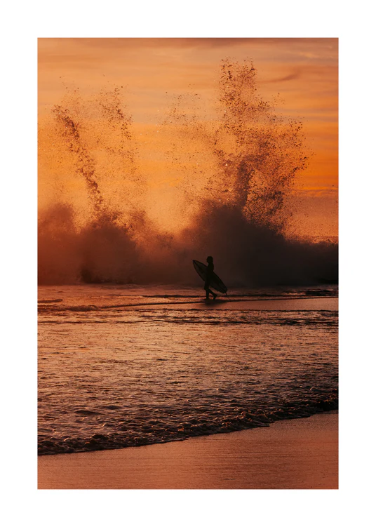 Surfer heading out into the orange waves during sunset.