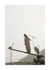 Woman balancing on a log above the beach on a misty day in the archipelago.